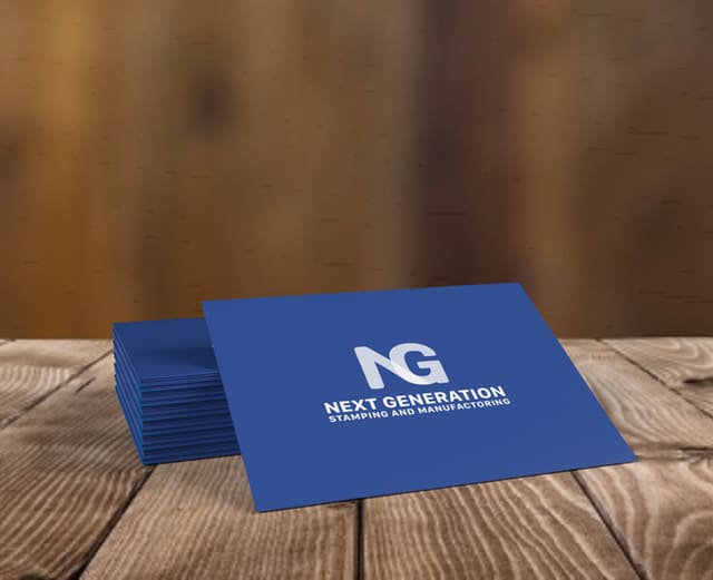 A stack of navy business cards on weathered wood, the NG monogram and full company name in white.
